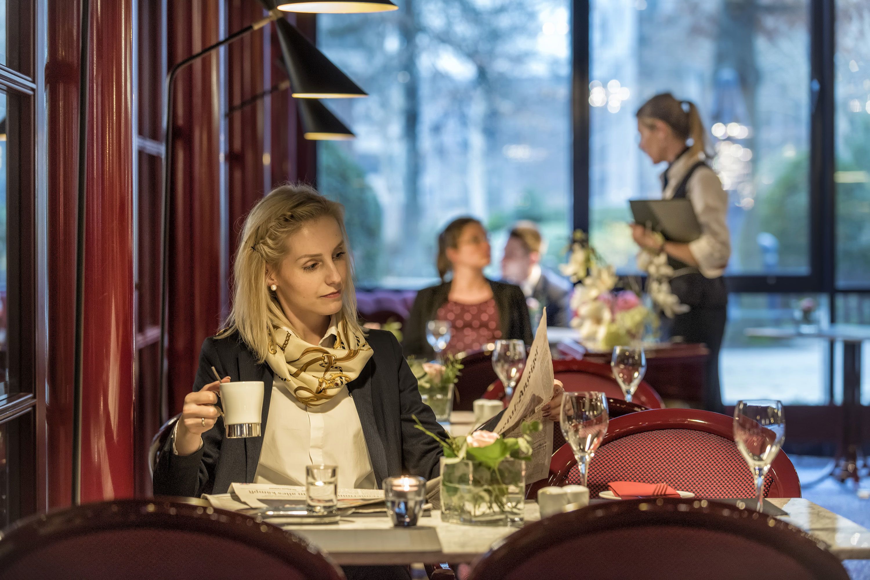 Zona de comedor con mesas dispuestas para comidas, incluyendo copas de vino y menús.