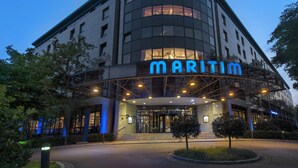 A modern building with a curved facade and the name "MARITIM" illuminated in blue letters. - Maritim Hotel Bremen (Bremen)