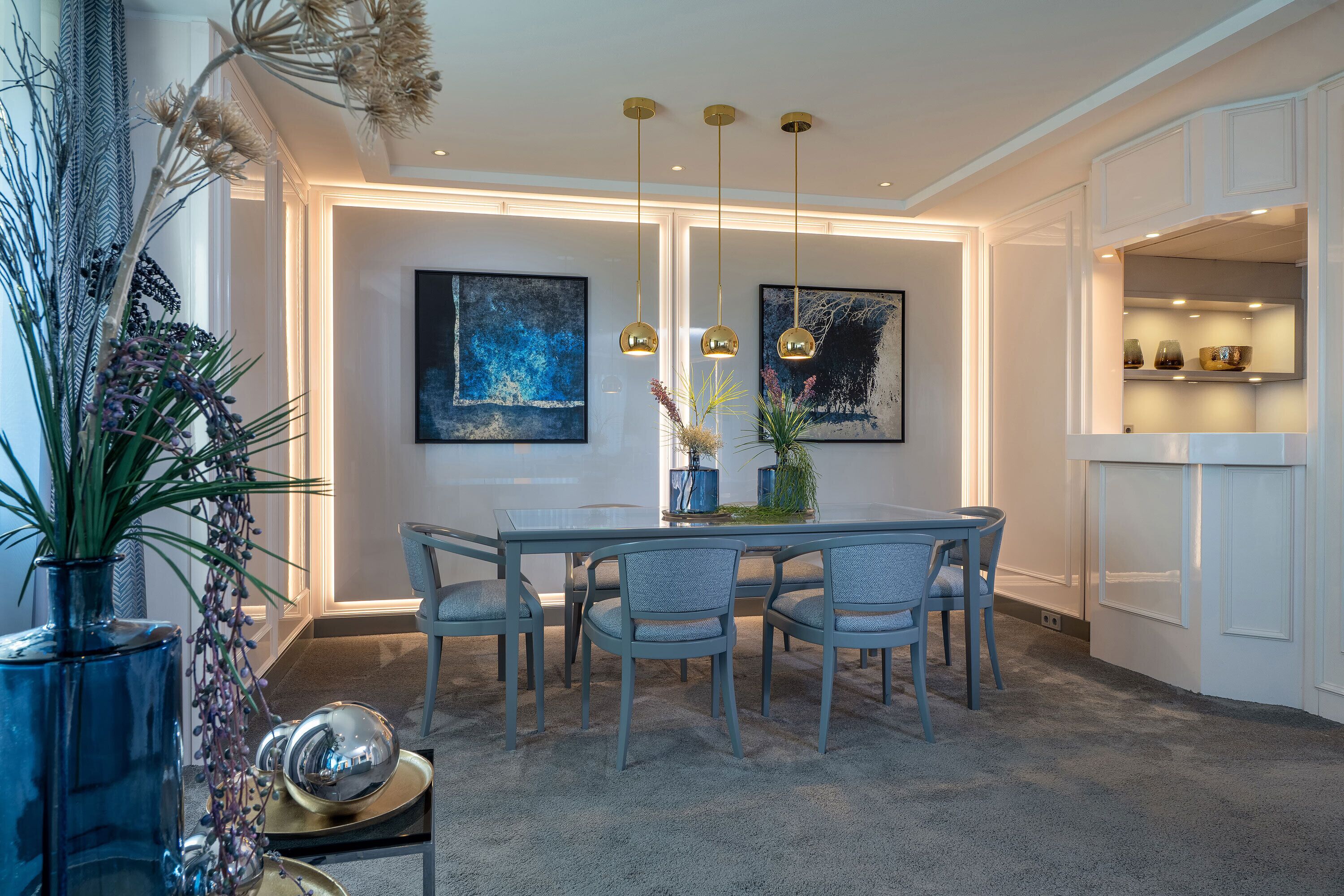 A dining area with a table, chairs, and pendant lights.