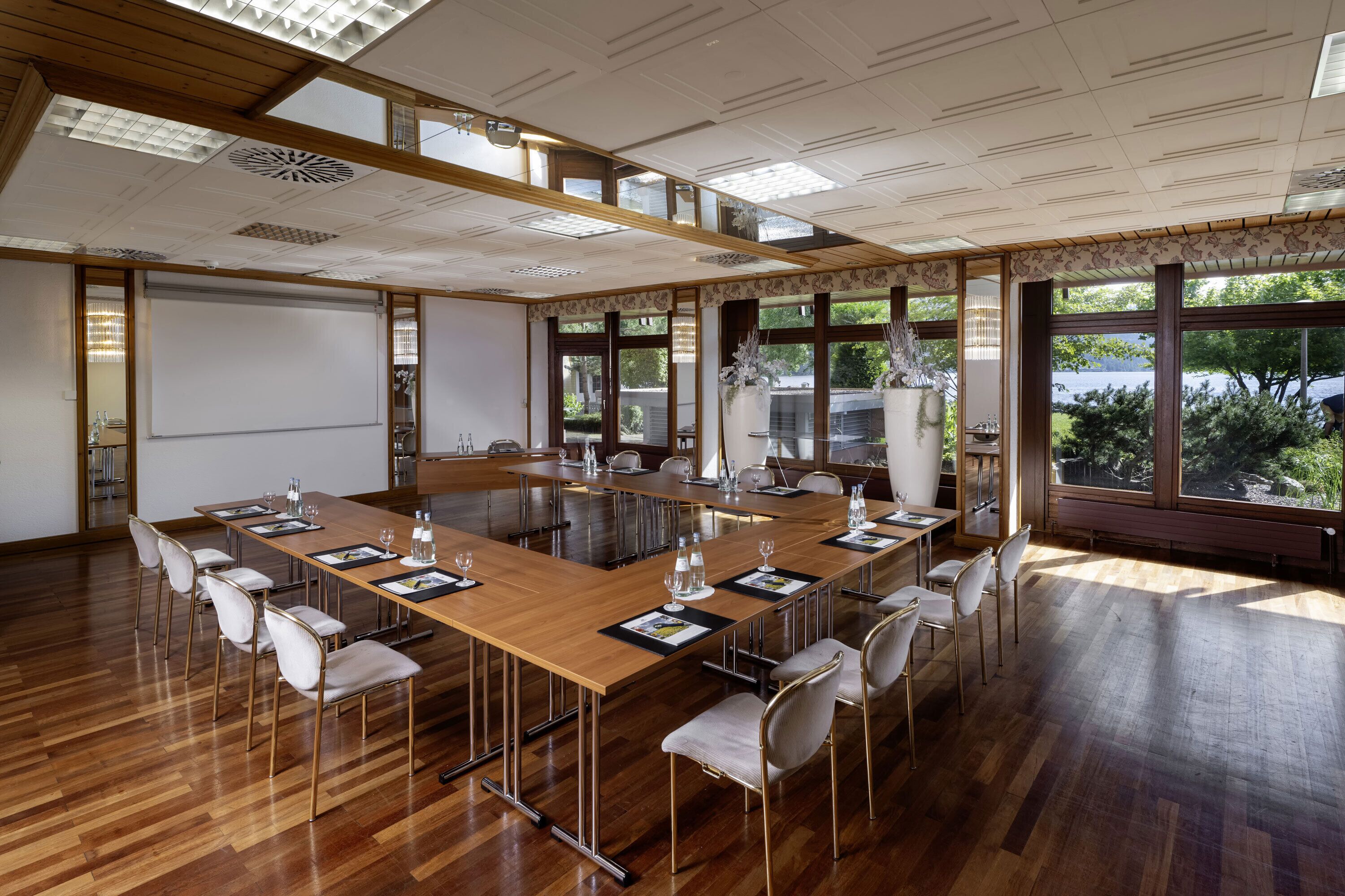 Une salle de conférence équipée d’une grande table, de chaises et d’un écran de projection.