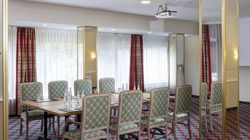 A conference room with a long table, multiple chairs, and a projector.