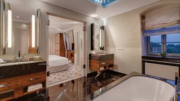 Ein modernes Badezimmer mit einer großzügigen Badewanne, einem Waschtisch mit Spiegel und einer Duschkabine.