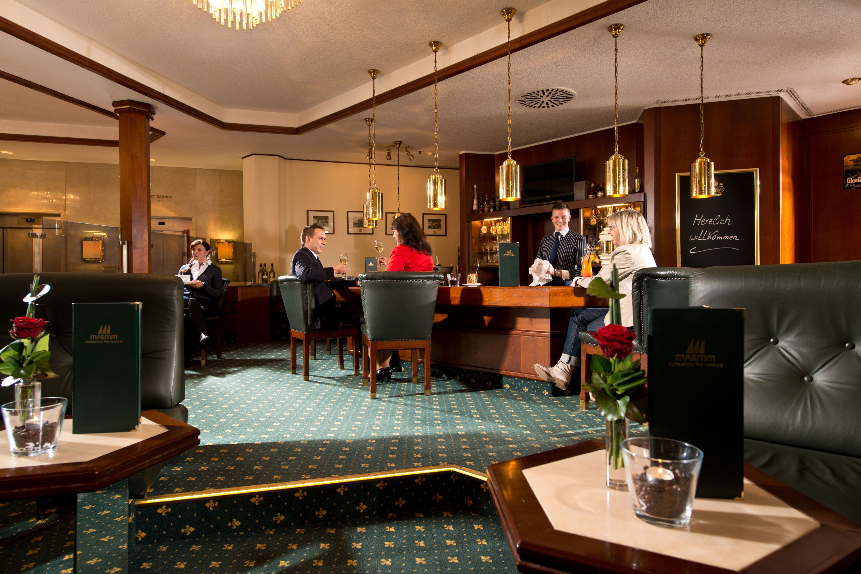 A hotel lobby with leather seating, a bar area, and a reception desk.