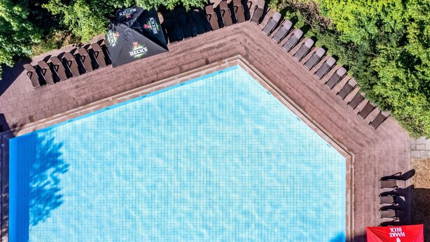 An aerial view of a swimming pool with lounge chairs and umbrellas.