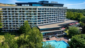 Un hôtel à plusieurs étages doté d’une piscine, d’un espace extérieur aménagé et offrant une vue sur le paysage environnant.