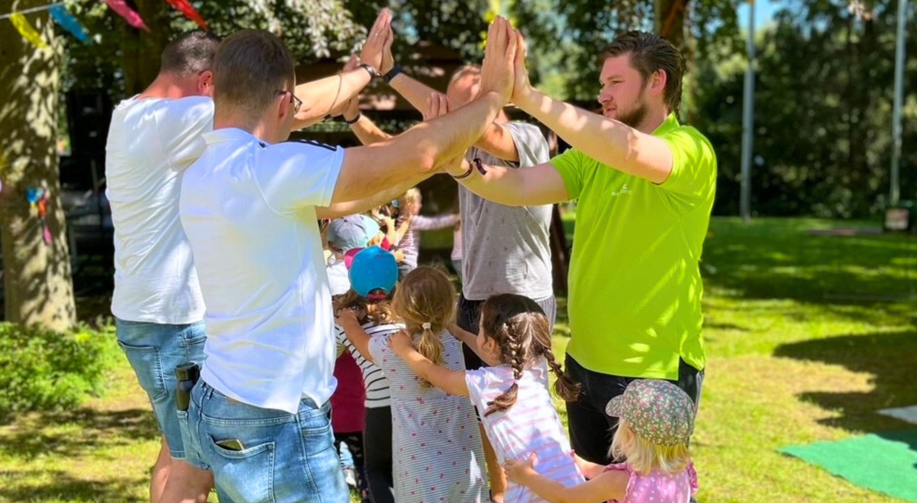 A group of people in a park with trees and grass.