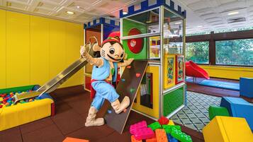 Un área de juegos con un tobogán, pared de escalar y bloques de construcción de colores.