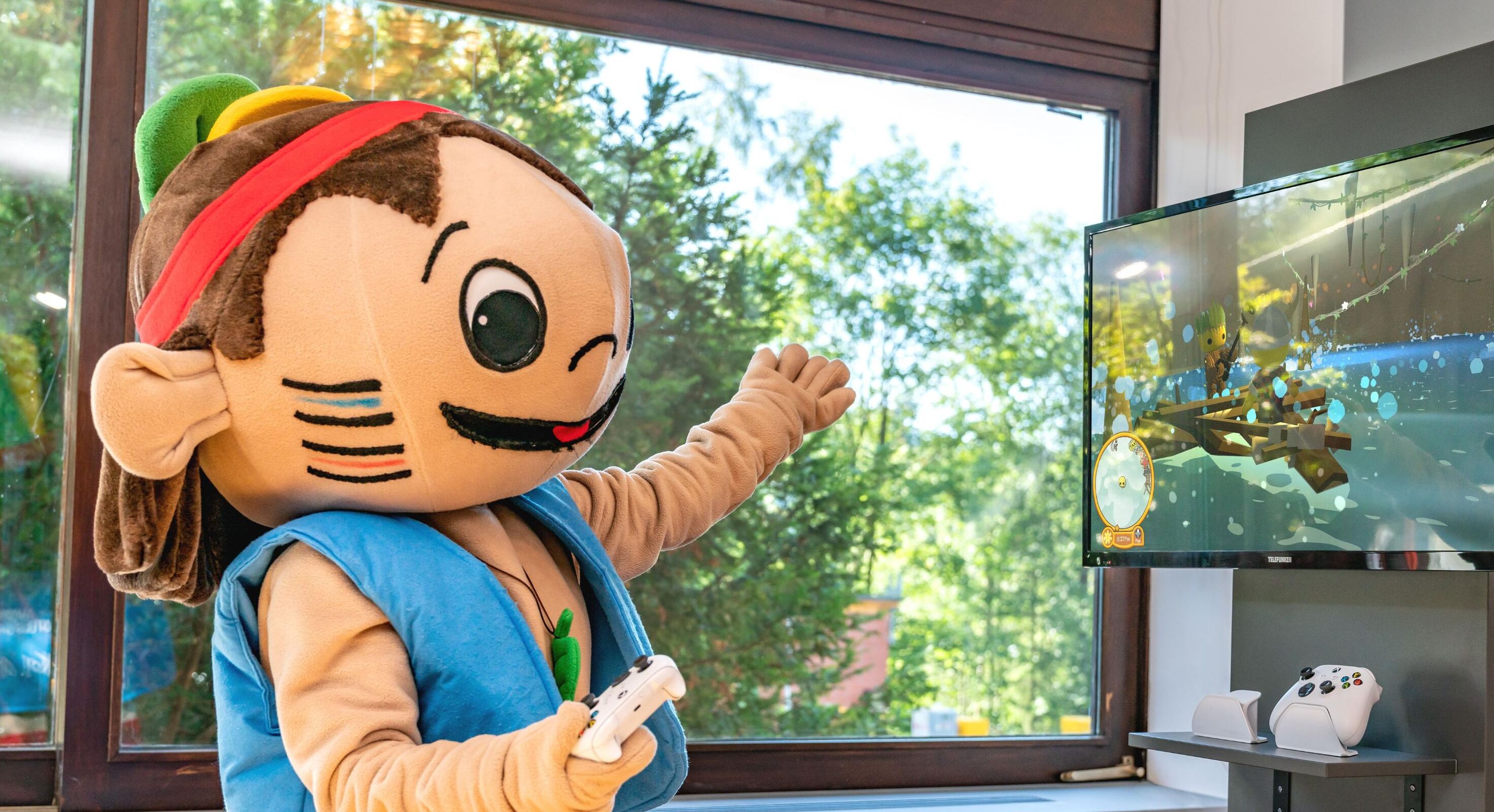 A mascot in a room with a large window, a TV, and a gaming console.