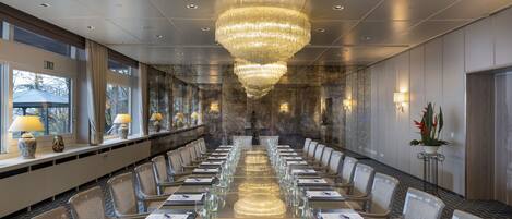 A conference room with a long table, chairs, and a chandelier.