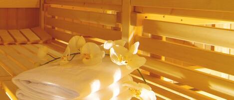 A wooden bench with a towel and white orchids on it.