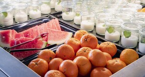 A buffet with oranges, watermelon, and milkshakes. - PLAZA Premium Timmendorfer Strand (Timmendorfer Strand)