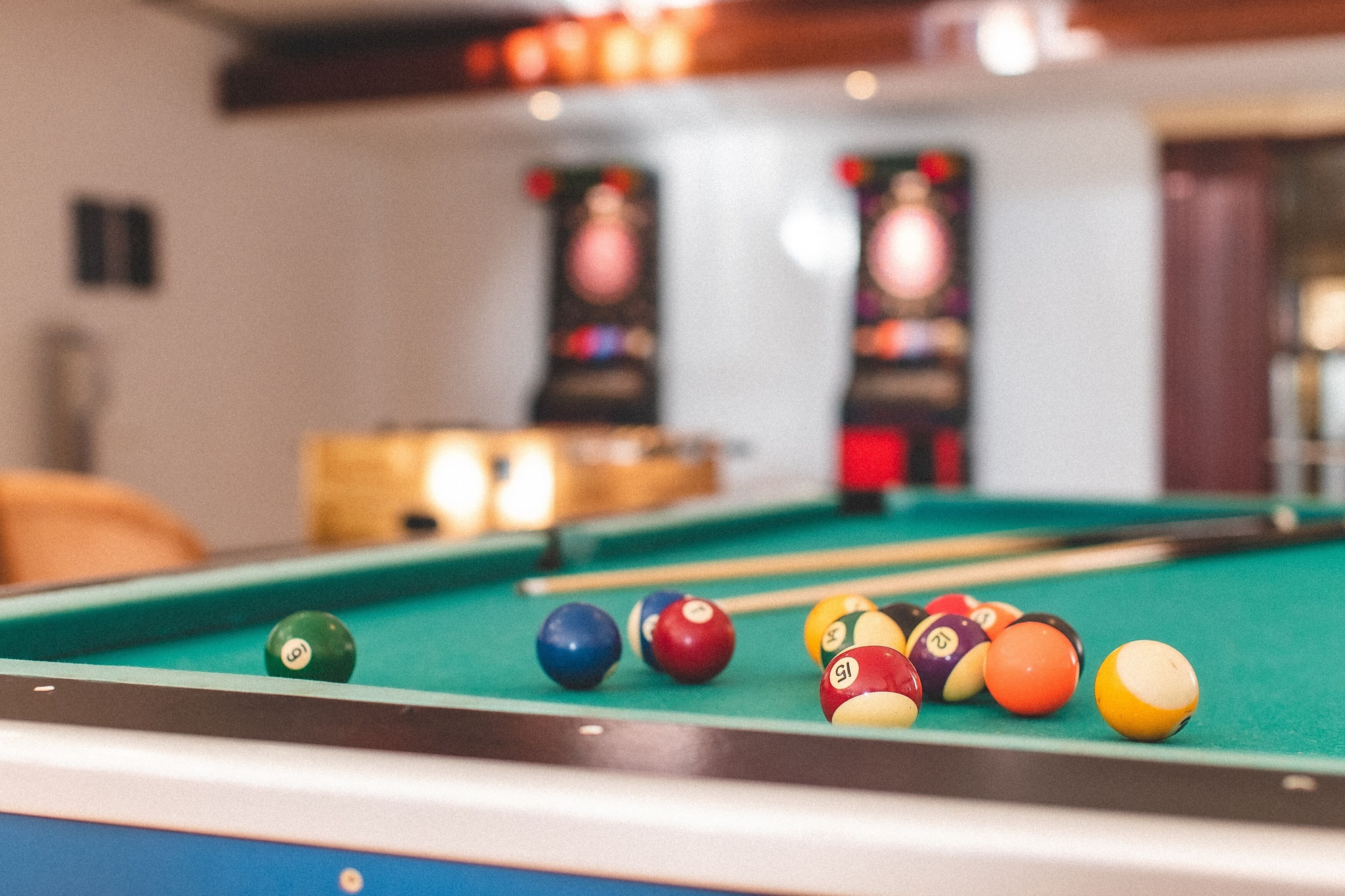 Une table de billard avec des billes de différentes couleurs et un queue de billard.