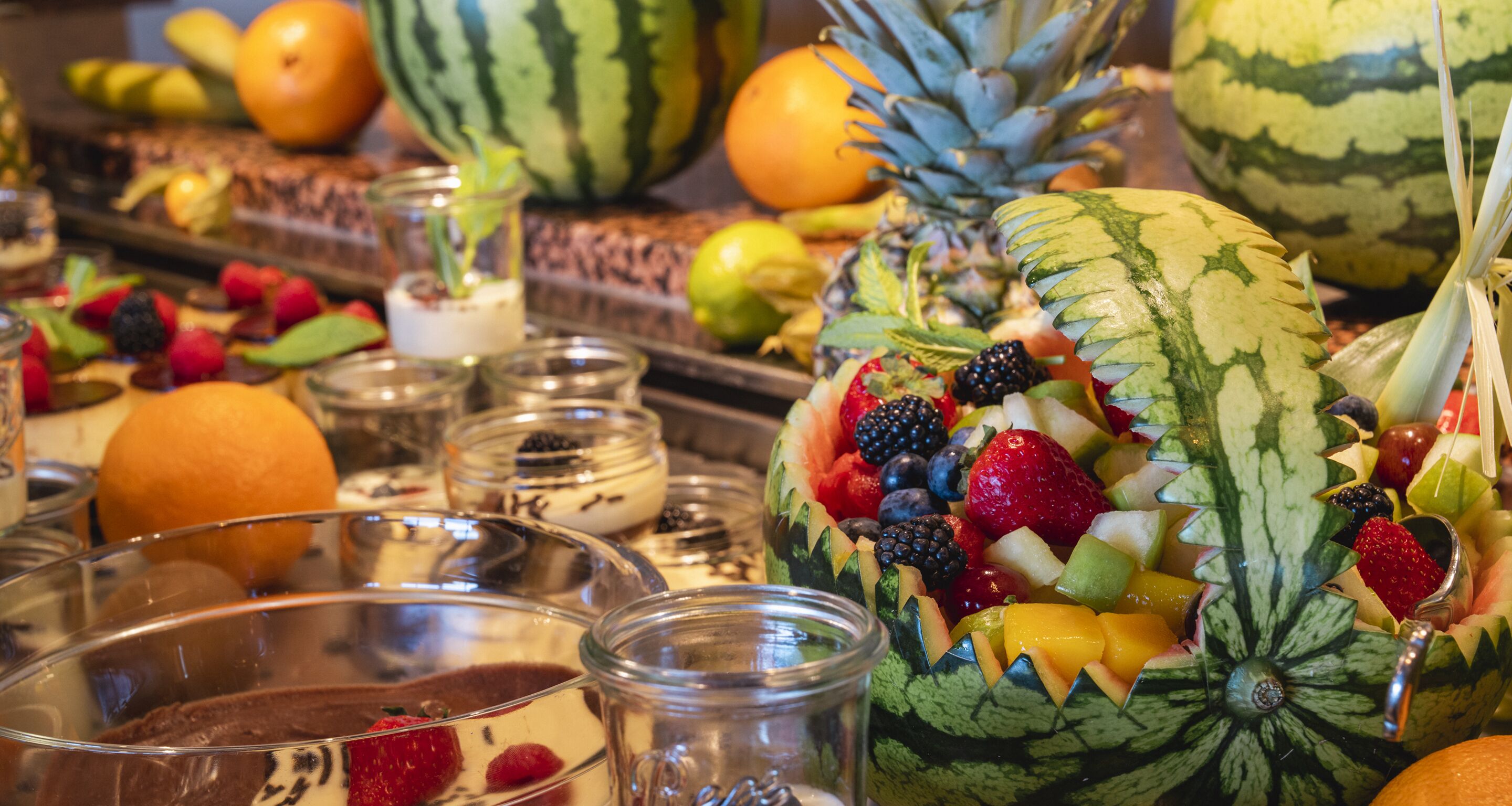 Una presentación de frutas con diversas variedades y una sandía como elemento central.