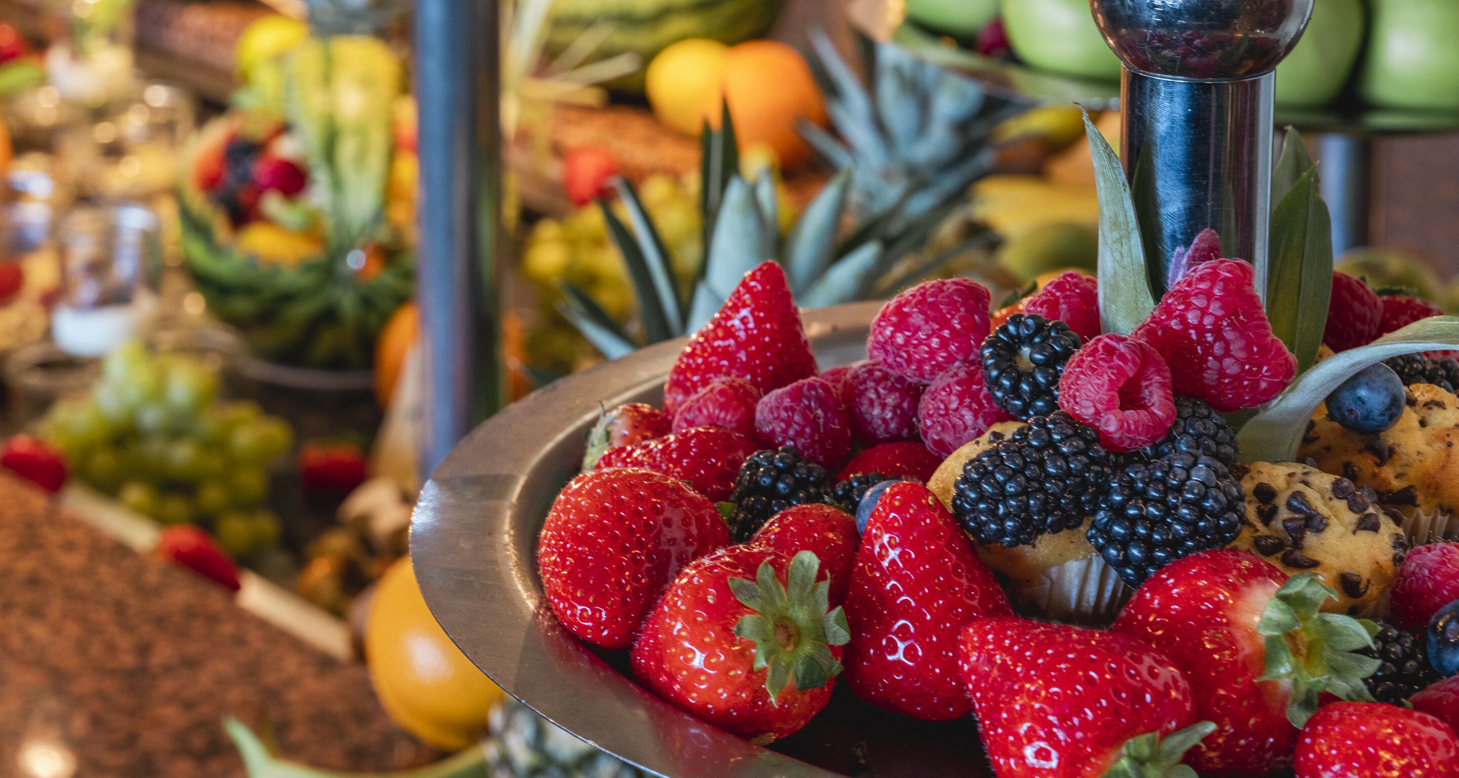 A metal tray filled with strawberries, raspberries, blackberries, and blueberries.