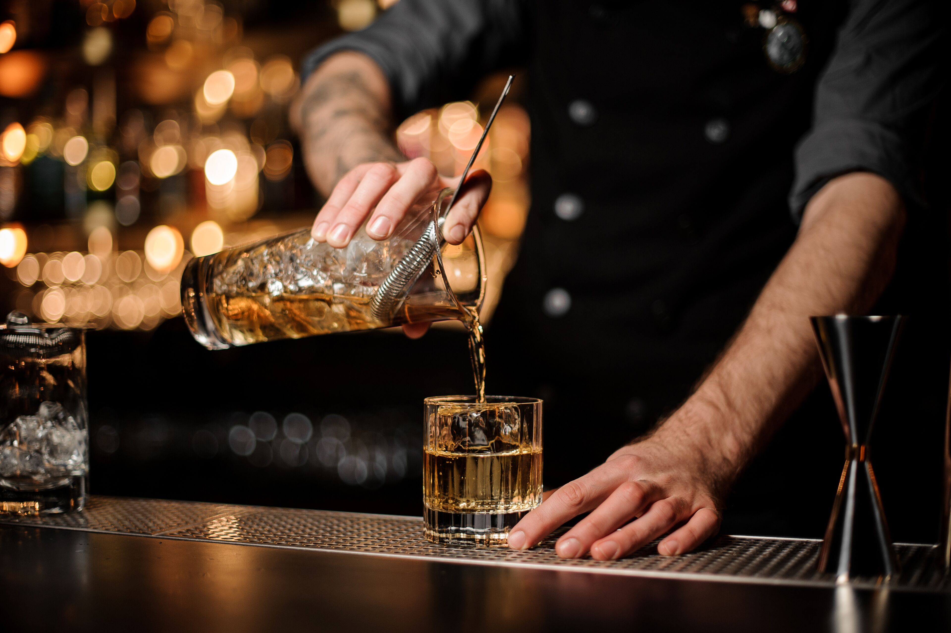 Een bartender schenkt een drankje in.