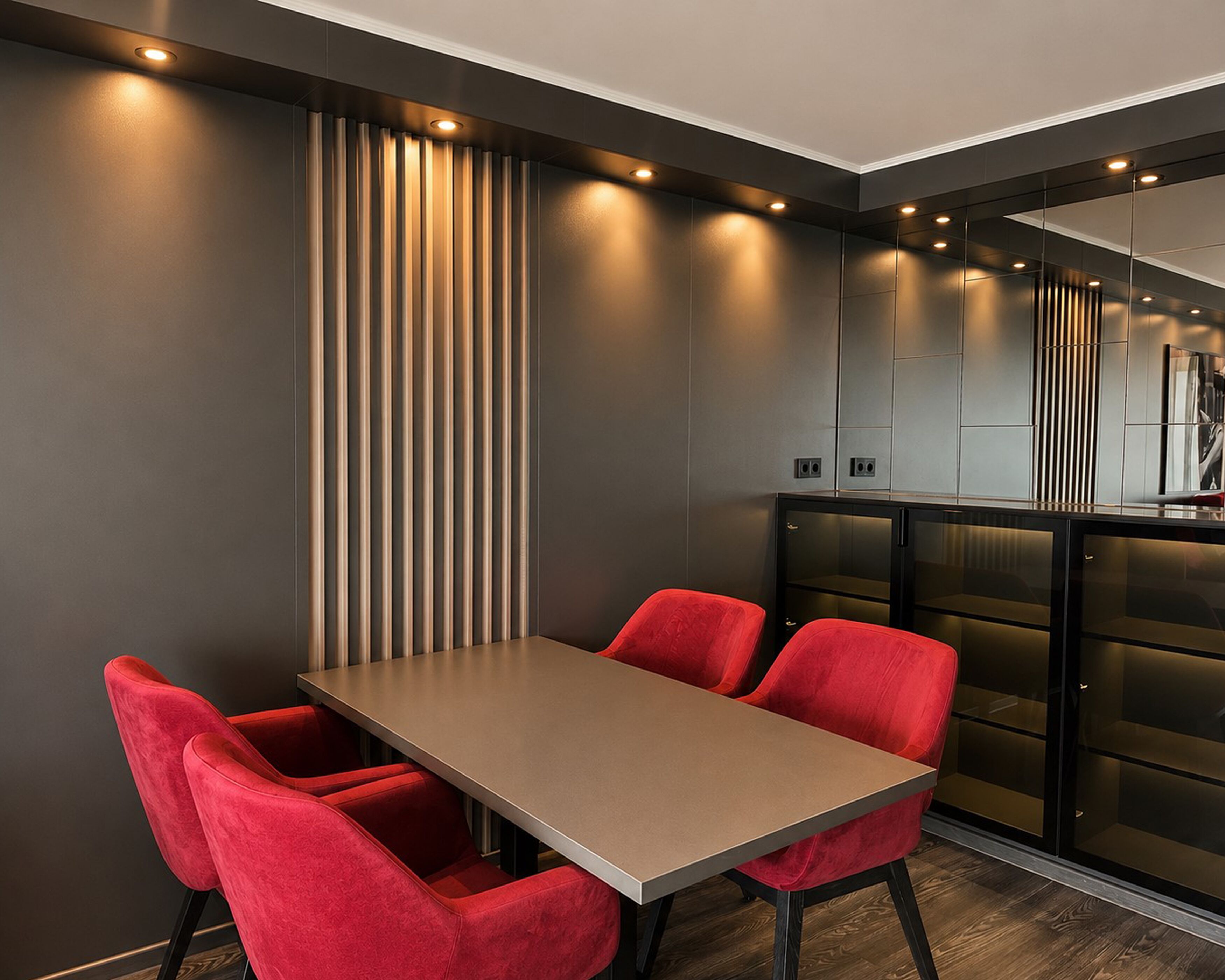 Un comedor moderno con una mesa rectangular y sillas tapizadas en rojo.
