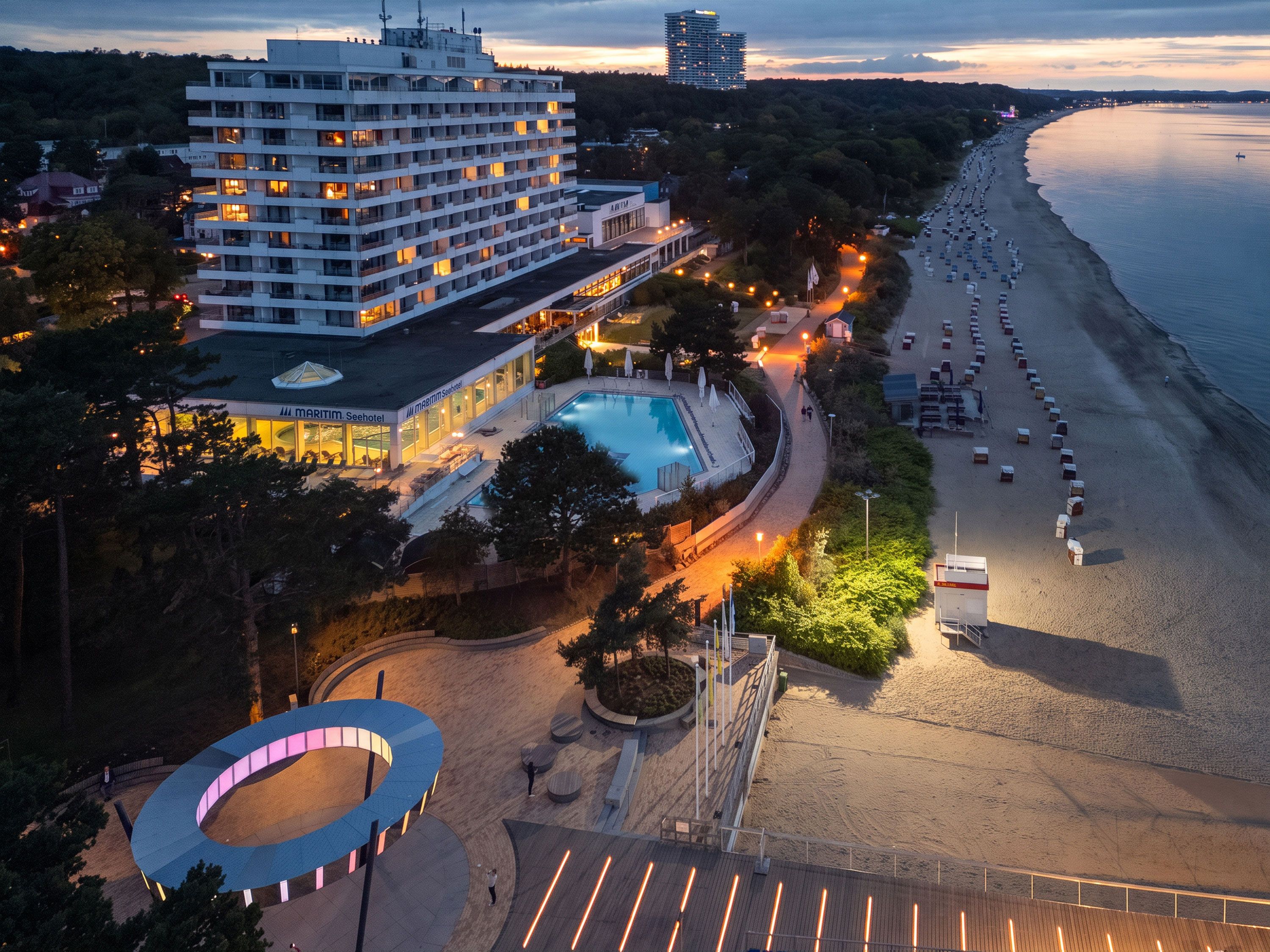 A hotel with a pool, beach access, and a circular outdoor area.