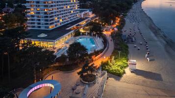 A hotel with a pool, beach access, and a circular outdoor area.