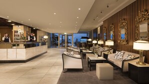 A hotel lobby with a reception desk, seating area, and large windows. - Maritim Seehotel Timmendorfer Strand (Timmendorfer Strand)