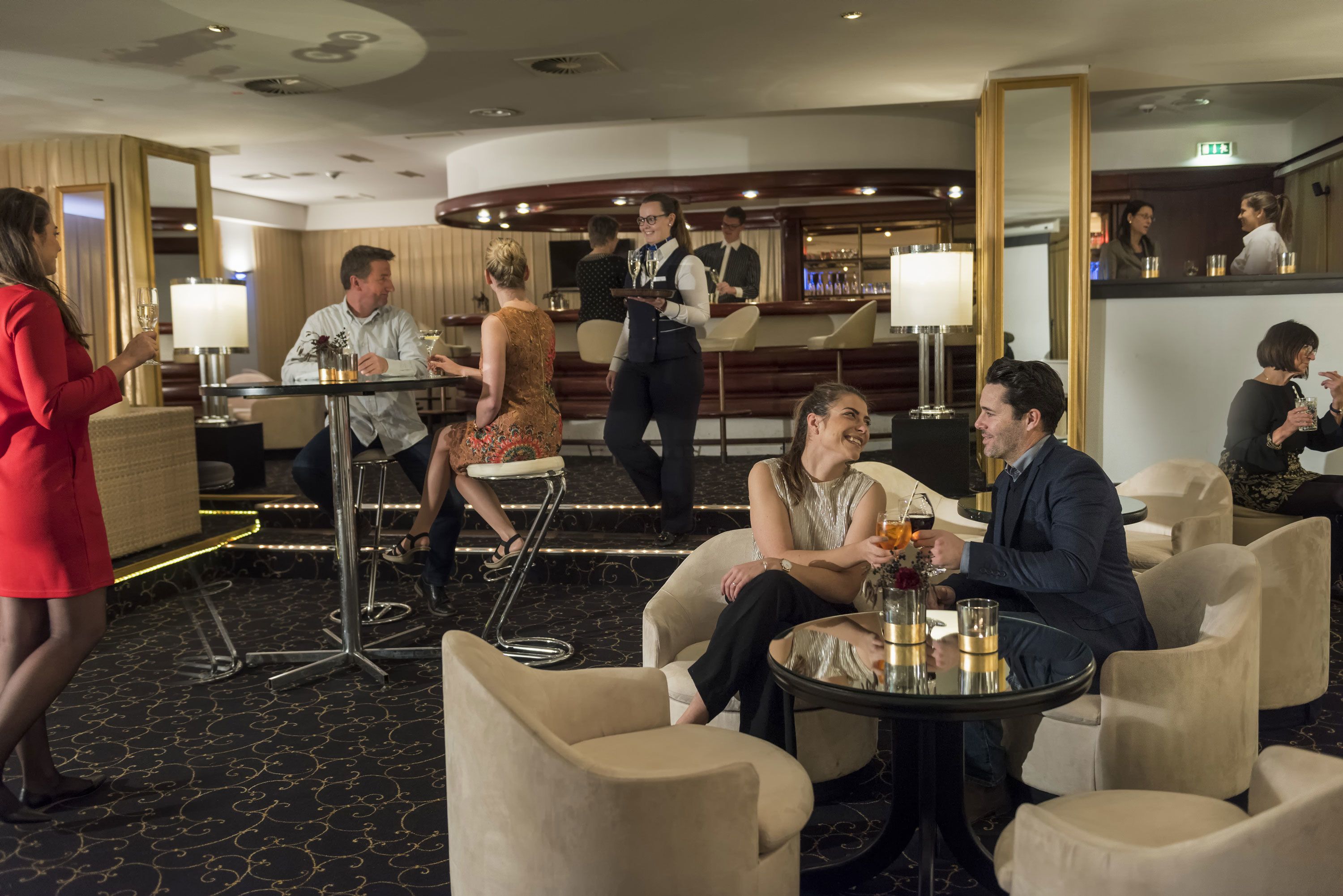 A hotel lobby with seating areas, a bar, and a reception desk.