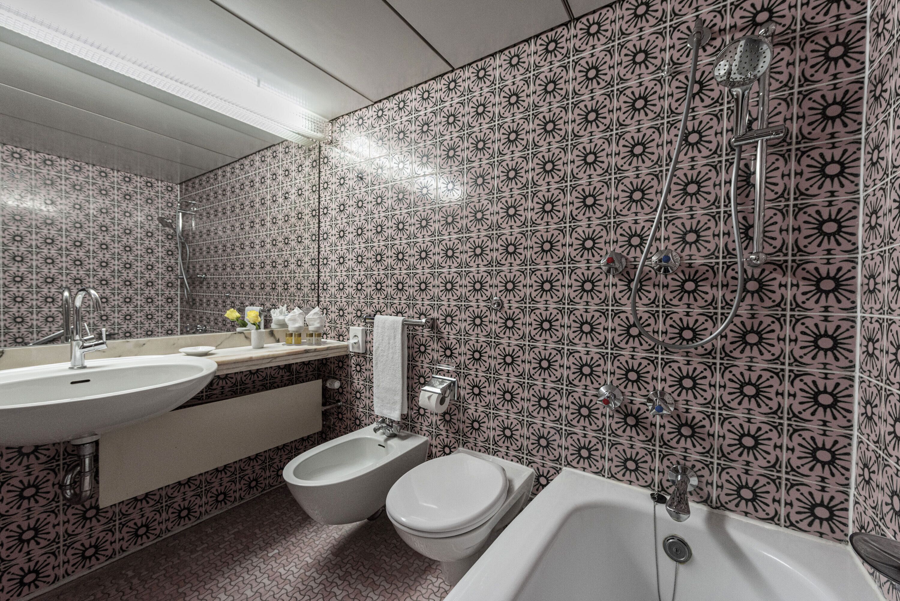 Ein Badezimmer mit Waschbecken, Bidet, Toilette und Badewanne.