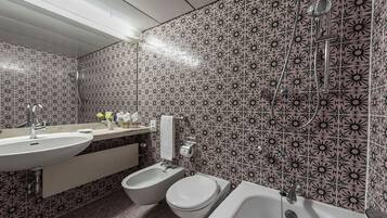 Ein Badezimmer mit Waschbecken, Bidet, Toilette und Badewanne.