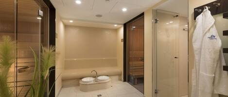A modern bathroom with a glass shower enclosure, a double sink vanity, and a towel rack.