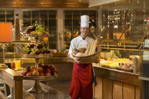 A buffet setup with various fruits, bread, and beverages. - Maritim Hotel Stuttgart (Stuttgart)