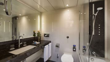 Une salle de bain moderne avec un grand miroir, un lavabo double, des toilettes et une douche à parois de verre.