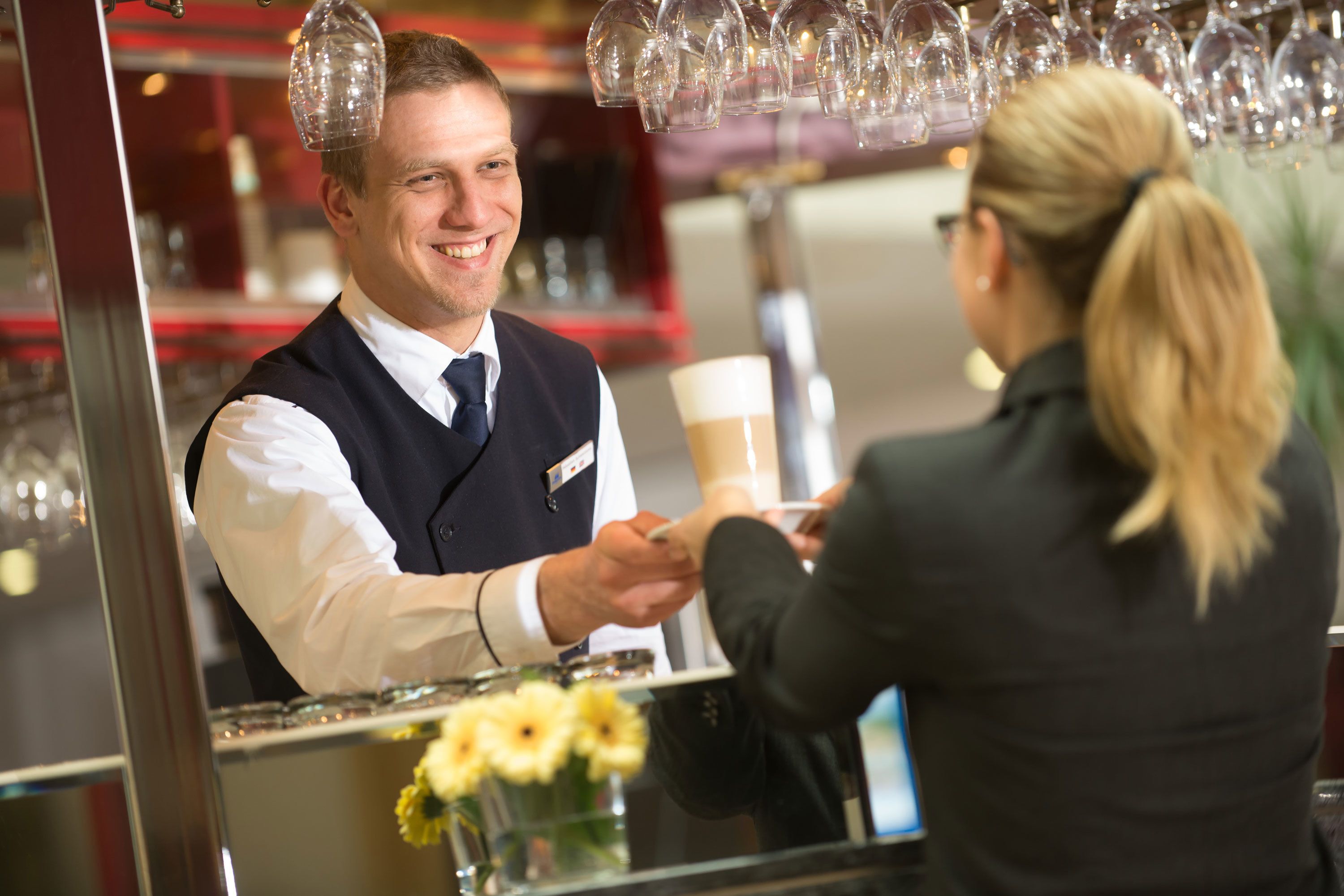 A bar area with a bartender and a customer.
