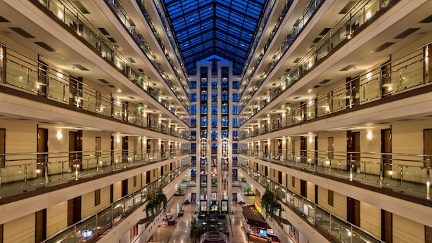 A multi-level hotel atrium with a central open space, glass railings, and a skylight. - Maritim Hotel Magdeburg (Magdeburg)