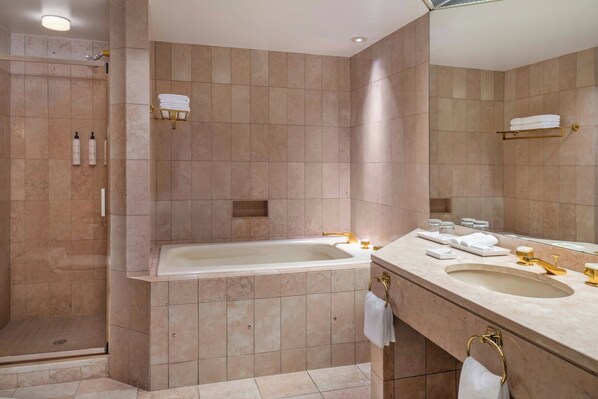 Une salle de bain moderne dotée d’une douche à l’italienne, d’une baignoire sur pieds et d’un meuble-lavabo avec un évier et un miroir.