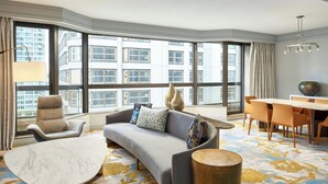 A modern hotel room with a large window, a sofa, a dining table, and a chair. - Metropolitan Hotel Vancouver by Marriott (Vancouver)