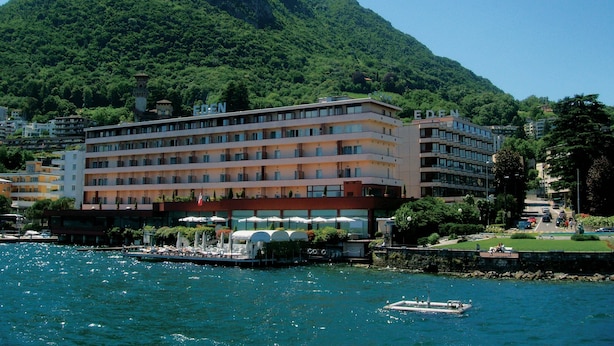 A hotel with multiple floors, balconies, and a view of a mountain. - Grand Hotel Eden (LUGANO)