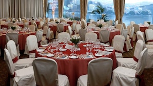 A banquet hall with round tables, white chairs, and red tablecloths. - Grand Hotel Eden (LUGANO)