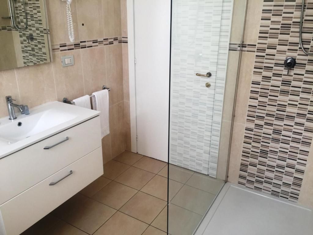 A bathroom with a white sink, mirror, and towel rack.