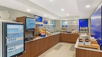 A breakfast bar with labeled dispensers for yogurt, eggs, and milk.
