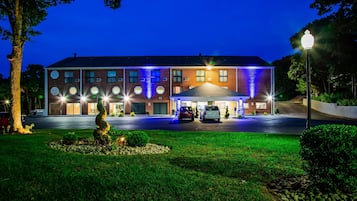 Hotel features a symmetrical facade with a central entrance and a well-manicured lawn.