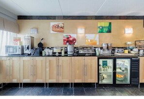 A modern kitchen with wooden cabinets, a refrigerator, and various appliances. - Quality Inn & Suites Mayo Clinic Area (Rochester)
