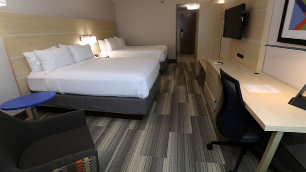 A hotel room with two beds, a desk, a chair, a TV, and a small table. - Holiday Inn Express Biloxi - Beach Blvd by IHG (Biloxi)