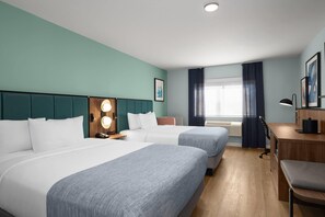 A hotel room with two beds, a desk, a chair, a desk lamp, a window with curtains, and a wall-mounted phone. - Wingate by Wyndham Farmington NM (Farmington)