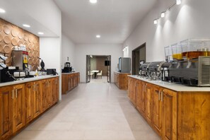 A modern kitchen with wooden cabinets, a central island, and a coffee station. - Wingate by Wyndham Farmington NM (Farmington)