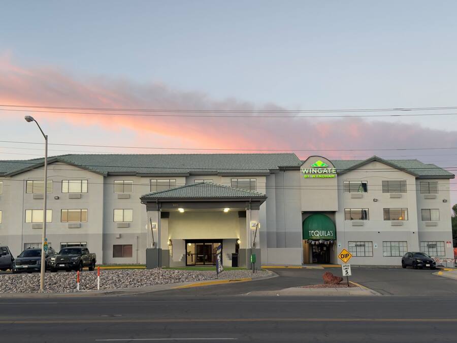 A hotel with a green sign reading "Wingate by Wyndham" and a "Tequila's" sign.