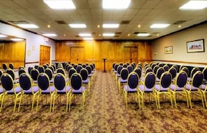 Conference room with carpeted floor, wooden paneling, and seating for events.