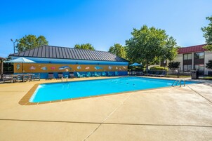 Una piscina al aire libre de temporada, sombrillas