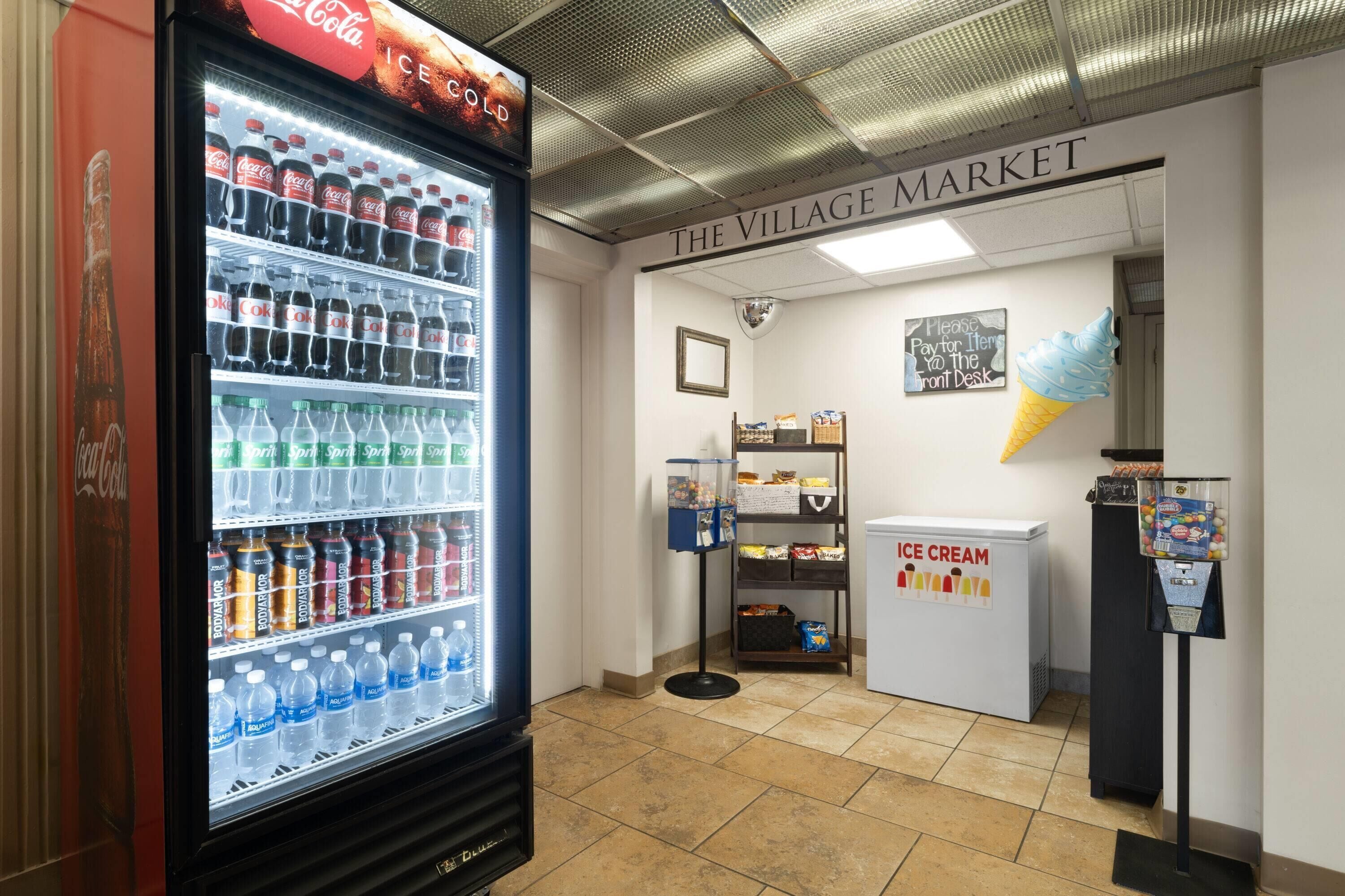 Un espace comprenant des distributeurs automatiques, avec un réfrigérateur pour les produits Coca-Cola, un autre pour les produits Sprite et un distributeur de glaces.