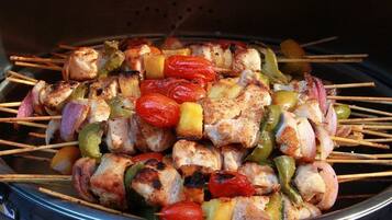 A grill with skewers of chicken, bell peppers, and onions.