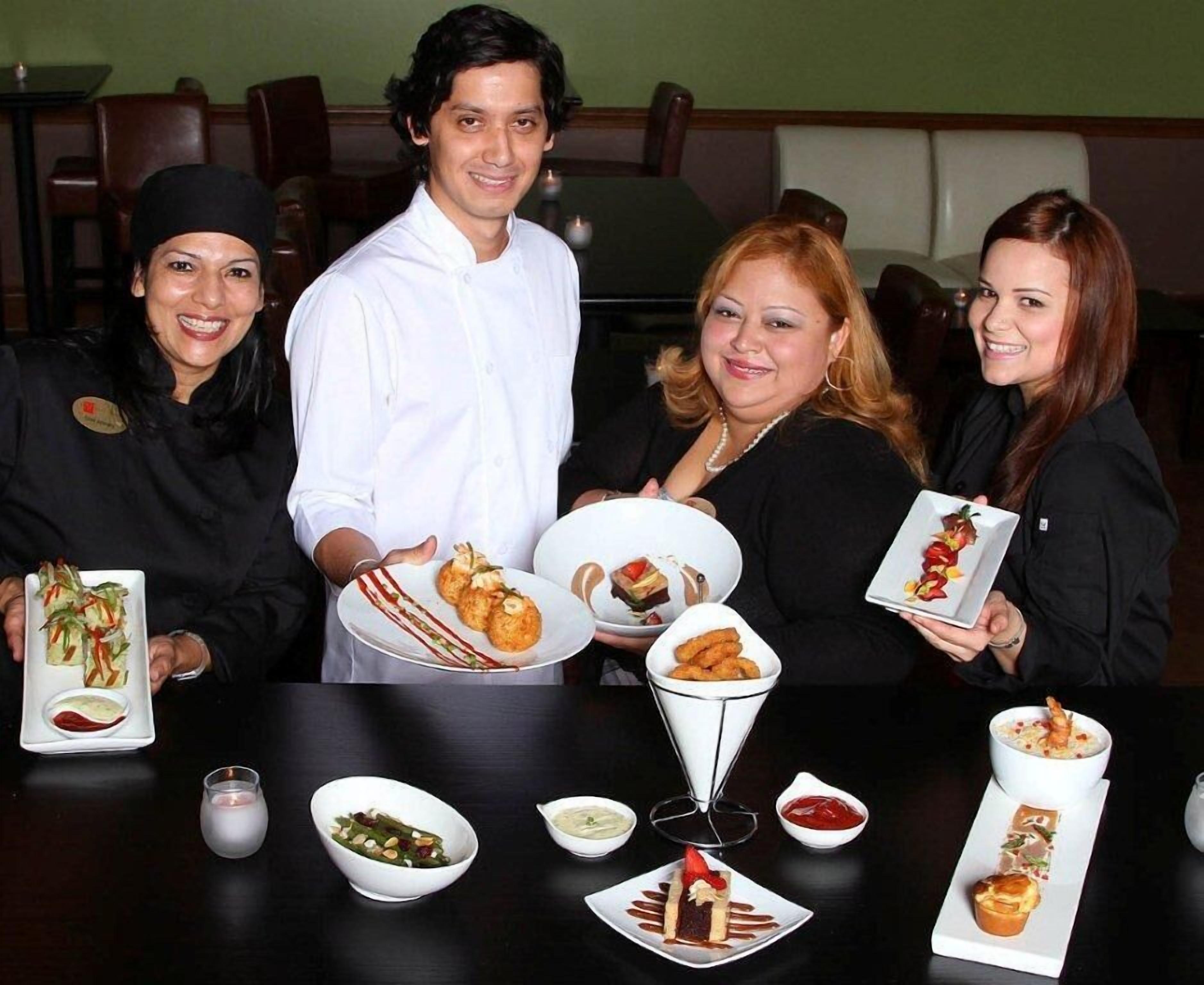 Um grupo de pessoas em um restaurante, com diversos pratos sobre a mesa.