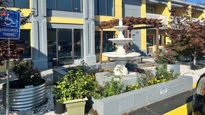 A building with a fountain, wheelchair parking sign, and outdoor plants. - Quality Inn Grand Rapids Near Dowtown (Grand Rapids)