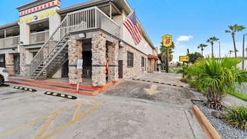 A building with a stone facade, a flag, and a sign for a restaurant.
